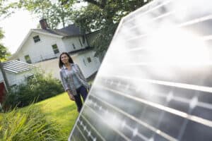 Summer gathering,A woman walking towards a solar panel in a farmhouse garden.